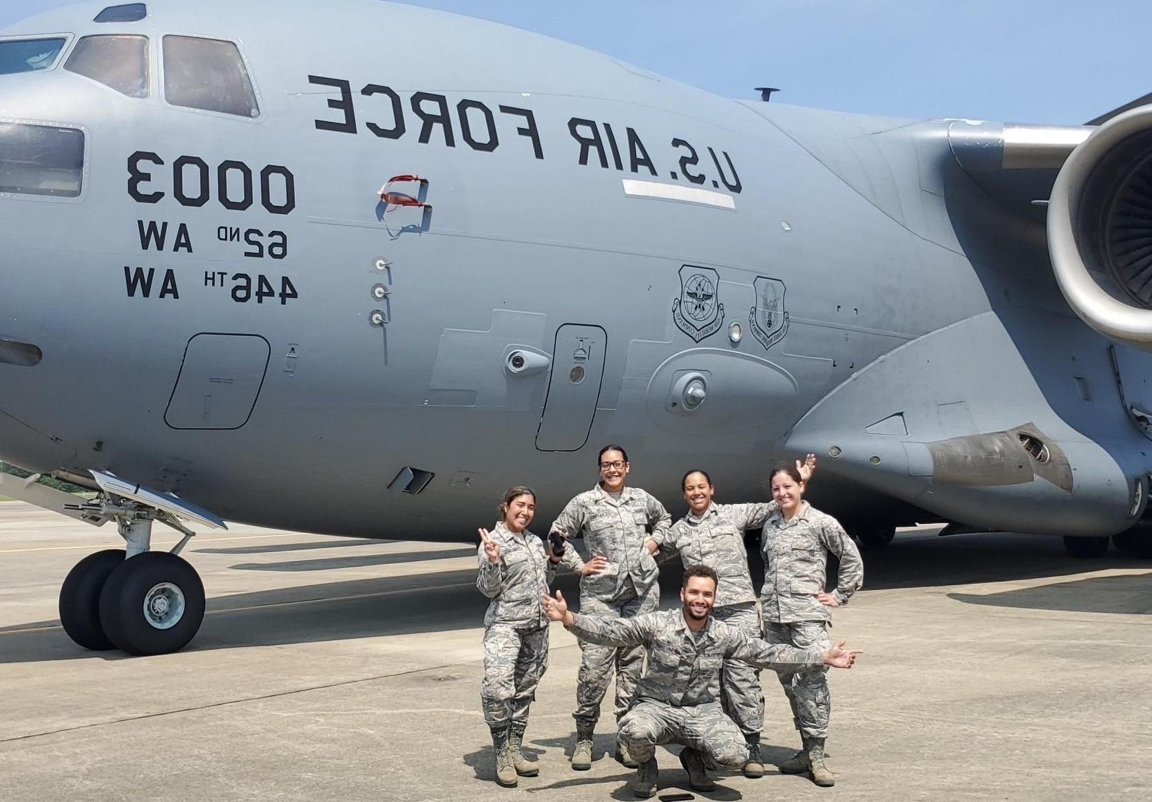 Samantha in front of a jet with colleagues